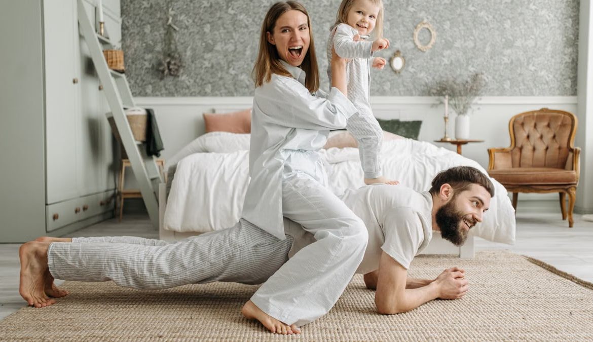 A cheerful family enjoys bonding and playing together on a cozy morning in a stylish bedroom.